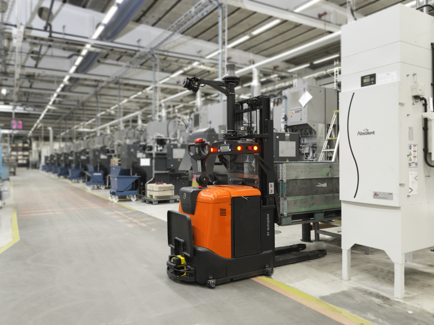 Automated guided vehicle haalt pallet met goederen op in productieomgeving