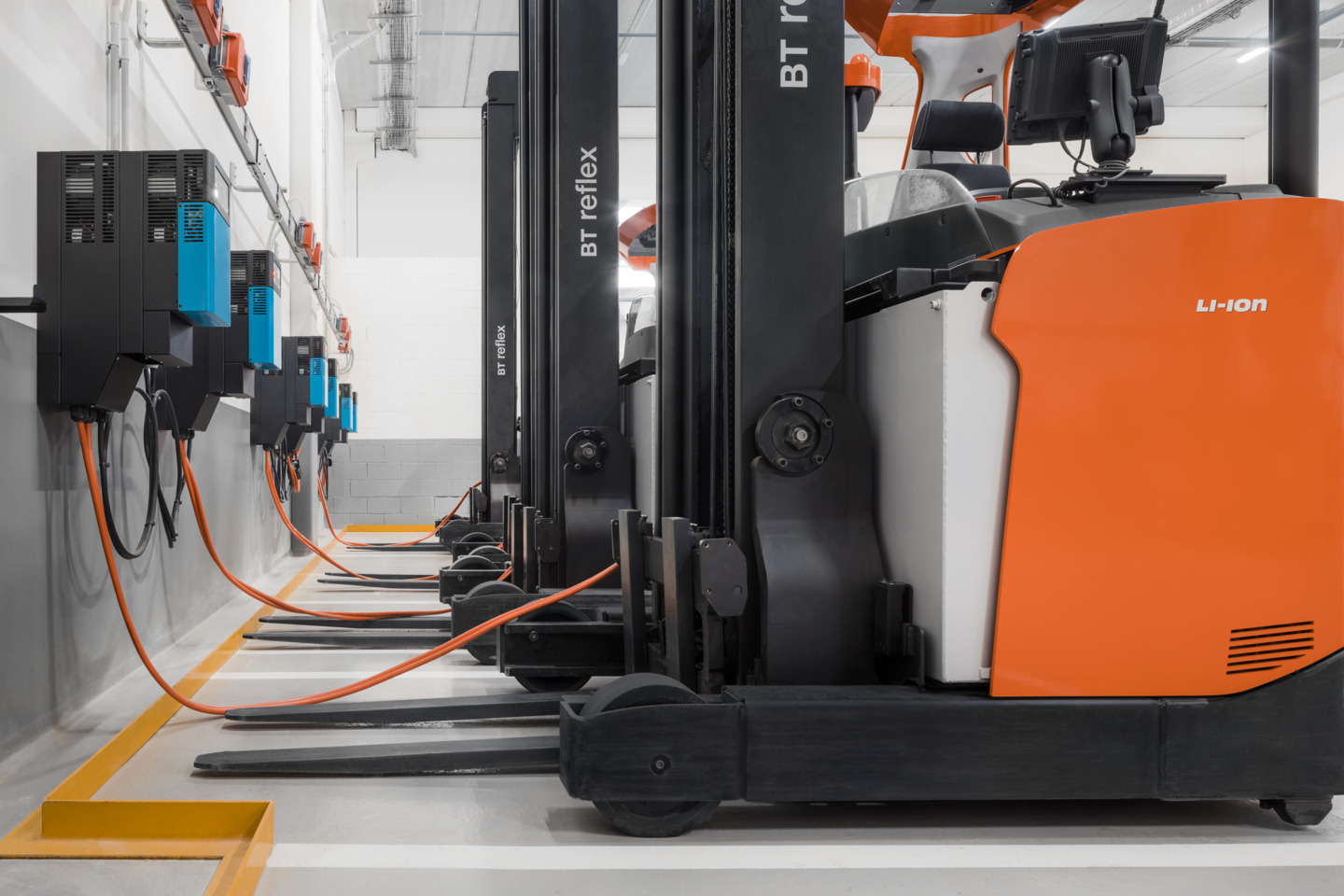 Toyota BT Reflex reachtrucks staan aan de oplader in het magazijn