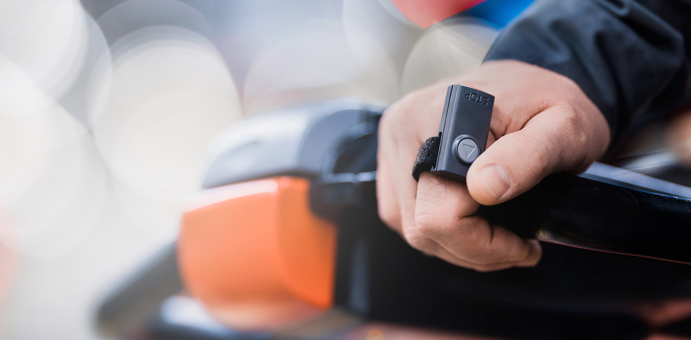 Kleine afstandsbediening om orderpicker met de bestuurder mee te laten rijden